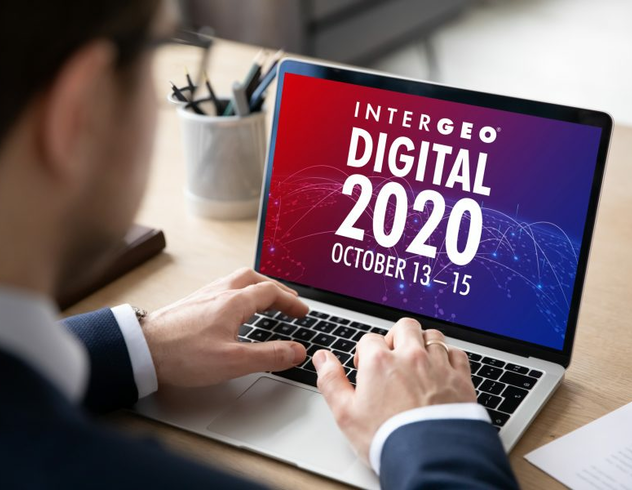 노트북으로 Intergeo Digital 2020을 보고 있는 정장 차림의 남자