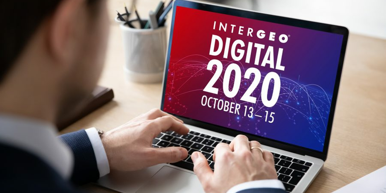 노트북으로 Intergeo Digital 2020을 보고 있는 정장 차림의 남자