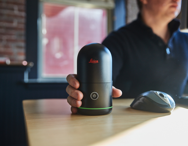 BLK360를 손에 들고 컴퓨터 책상에 앉아 있는 사람
