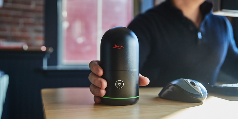 BLK360를 손에 들고 컴퓨터 책상에 앉아 있는 사람